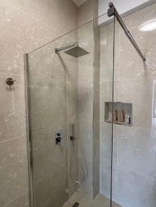 a shower with a glass door in a bathroom at Nostos Palase in Dhërmi +62 photos