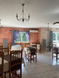 a dining room with tables and chairs and a chandelier at Les Mimosas in Lunel