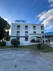 a hotel with a parking lot in front of it at Les Mimosas in Lunel