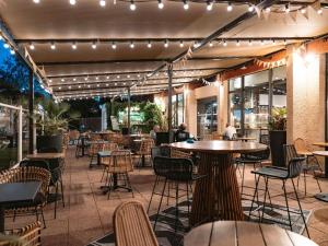 a patio with tables and chairs and lights at ibis Marseille Provence Aéroport in Marignane