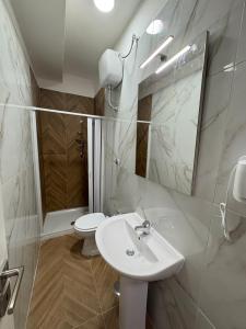 a white bathroom with a sink and a toilet at B&B Napul'è in Naples