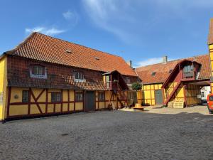 a group of buildings with orange and yellow at Købmandsgaarden Kerteminde in Kerteminde