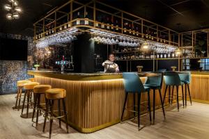 a bar with a person standing behind the counter at NH Amsterdam Schiphol Airport in Hoofddorp