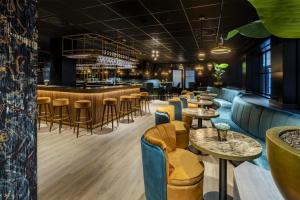 a restaurant with tables and chairs and a bar at NH Amsterdam Schiphol Airport in Hoofddorp