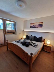 a bedroom with a large wooden bed with two lamps at Apart Kröll in Schlitters