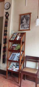 a book shelf with magazines and a chair next to a clock at Villa Saykham in Luang Prabang