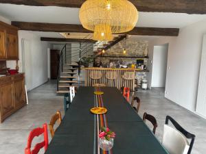 a dining room with a green table and chairs at Maison Arios in Came