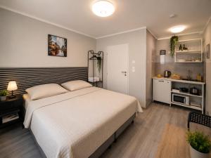 a bedroom with a large bed and a kitchen at Modern Living Apartment Hotel in Nuremberg