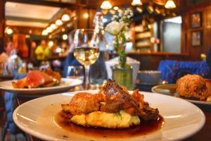 a plate of food on a table with a glass of wine at Scotsman's Pack Hotel in Hathersage