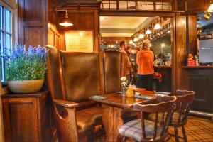 a restaurant with a table and people in a bar at Scotsman's Pack Hotel in Hathersage
