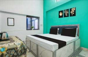 a bedroom with a large bed with a green wall at Samrat Hotel in Sambhal