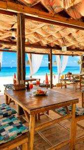 a wooden table with a plate of food on a beach at Zava Nungwi in Nungwi