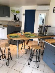 a kitchen with a wooden table and stools at Chalet La Dragonniere in Vias