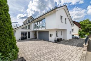 a white house with a driveway at Ferienwohnung Jeannette in Balingen