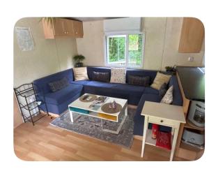 a living room with a blue couch and a table at Gite de la colline des rois in Verlin