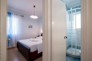 a bedroom with a bed and a bathroom with a tub at Corfu Glyfada Beach Apartment 86 in Glyfada