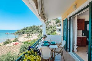 a balcony with a table and chairs and the ocean at Corfu Glyfada Beach Apartment 86 in Glyfada