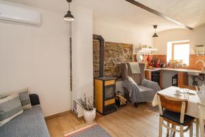 a living room with a wood stove and a kitchen at Apartmán Maštal in Osek