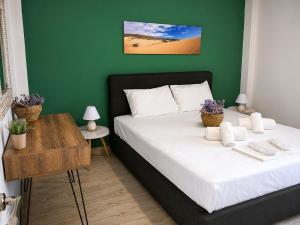 a bedroom with a bed with a green wall at TERRA LEMNIA in Moúdhros