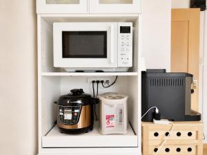 a microwave oven sitting on top of a shelf at K2Guesthouse Konohana in Osaka