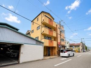 a white car parked in front of a building at K2Guesthouse Konohana in Osaka