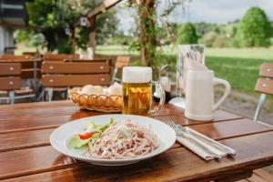 a plate of food on a wooden table with a drink at Chambtaler Hof in Runding