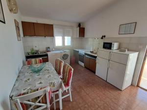 a kitchen with a table and chairs and a kitchen with a refrigerator at Tucepi Kamena 57 in Tučepi +17 photos