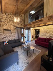 a living room with couches and a brick wall at Hotel Apartamentos Casas da Fortaleza in Lugo