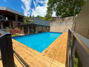 a large swimming pool with a wooden deck at Mountain Symphony House Dilijan in Dilijan
