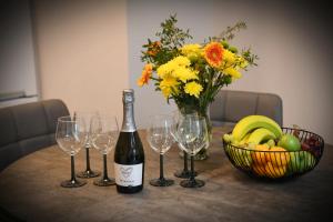 a bottle of wine and glasses on a table with a bowl of fruit at Coach House Accommodation - Room 3 in Carrick on Shannon