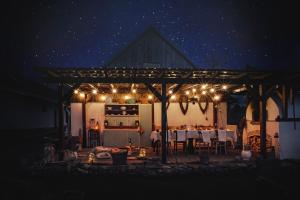 a table and chairs under a pergola at night at Apartmán Maštal in Osek