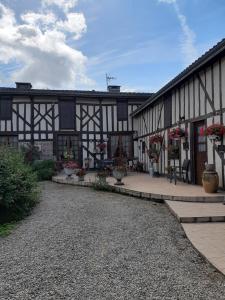 a black and white building with a patio with flowers at La ferme sympa in Droyes
