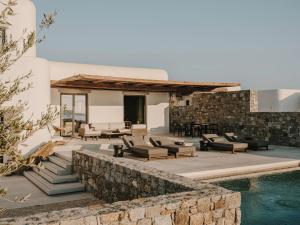 a patio with couches and chairs next to a pool at Kalesma Mykonos in Ornos +52 photos