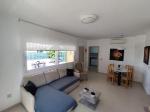 a living room with a blue couch and a table at Chalet adosado acogedor Busot in Alicante