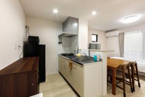 a kitchen with a sink and a wooden table at Anecis名楽町 in Nagoya