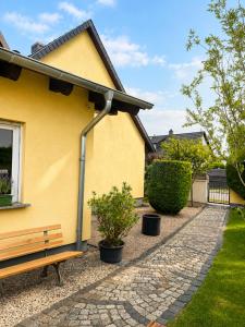 a yellow house with a bench in front of it at Haus an der Bachschleife in Arnstadt