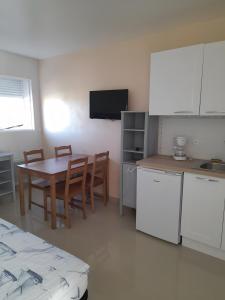 a kitchen and dining room with a table and cabinets at Césaria in Loupian