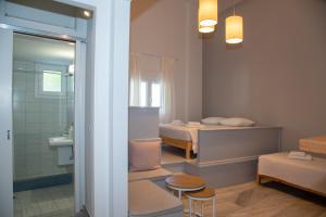 a small room with two beds and a bathroom at Flora in Tinos