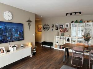a living room with a table and a clock on the wall at Rofabær 45 in Reykjavík