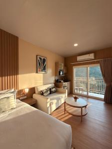 a hotel room with a bed and a couch at Ko Tao Paradise Resort in Ko Tao