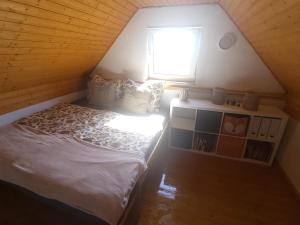 a small bedroom with a bed and a window at Chata u lesa in Divec