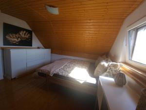 a small bedroom with a bed and a window at Chata u lesa in Divec