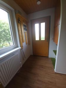 a hallway with a wooden door and a window at Chata u lesa in Divec