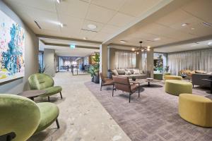 a waiting room with green chairs and tables at Frich`s Hotel Surnadal in Surnadal