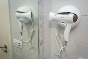 a hairdryer hanging on a wall in a bathroom at Apartamentos Raices in Cee
