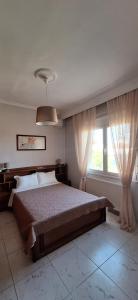 a bedroom with a large bed and a window at Imeros Summer Home in Ímeros