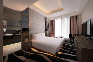 a hotel room with a bed and a television at Hotel Madera Hong Kong in Hong Kong