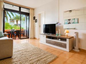 a living room with a tv and a couch at Primavera Pool Paradise in Arona +4 photos