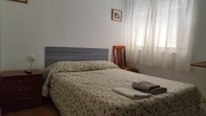 a bedroom with a bed with two towels on it at Hostal Restaurante Moderno in Cistierna
