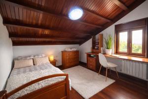 a bedroom with a bed and a desk and a window at Casa abuelo Ramón in Narón